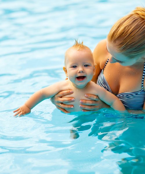 mother and baby swim in pool